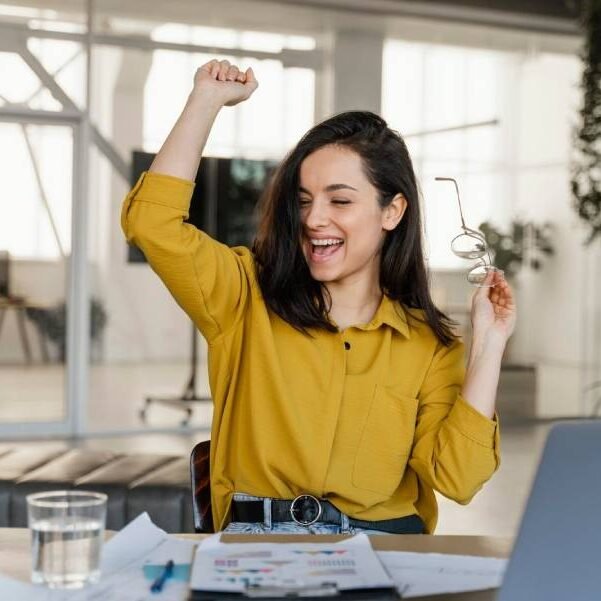 Empresária comemorando a produtividade alcançada no trabalho depois de um atendimento de massagem no Espaço Leocádio