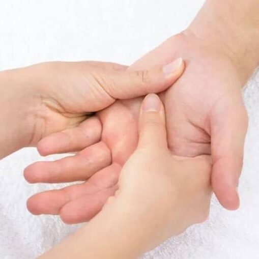 Massagem relaxante sendo aplicada na palma da mão por um Massagista