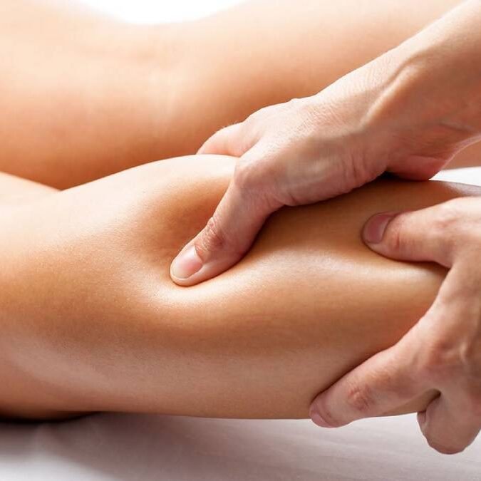 Massoterapeuta aplicando liberação miofascial na panturrilha de uma paciente