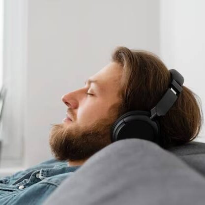 Homem dormindo em um sofá com fones de ouvido ao som de uma música relaxante