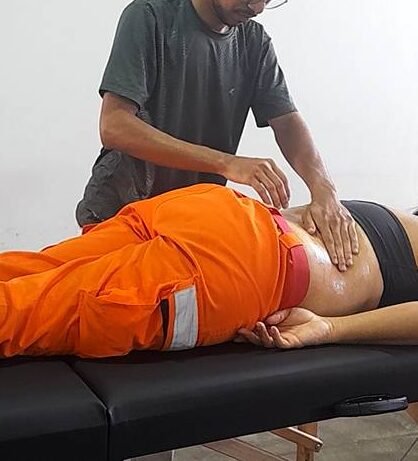 Massoterapeuta Leocádio aplicando técnicas manuais terapêuticas em paciente bombeira com dor e pontos gatilhos na região de lombar