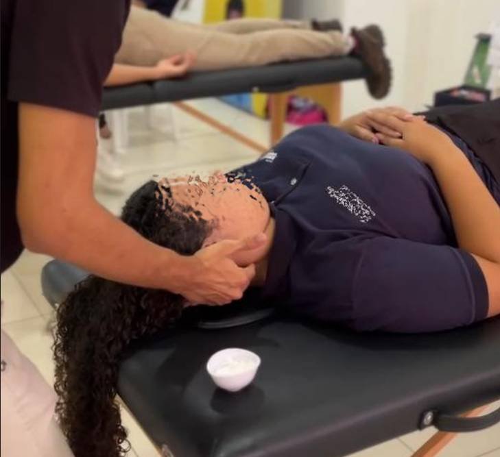 Massoterapeuta aplicando técnicas de massagem relaxantes em paciente na região de cabeça e pescoço