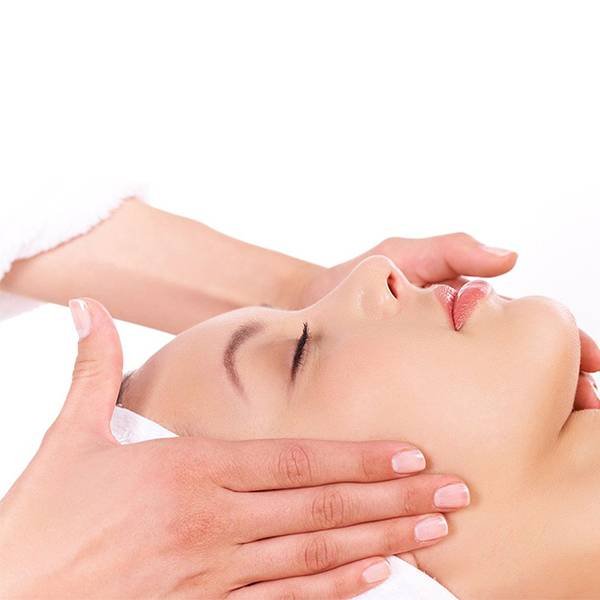 Massagem linfática ou drenagem linfática sendo realizada em rosto de paciente por uma massoterapeuta