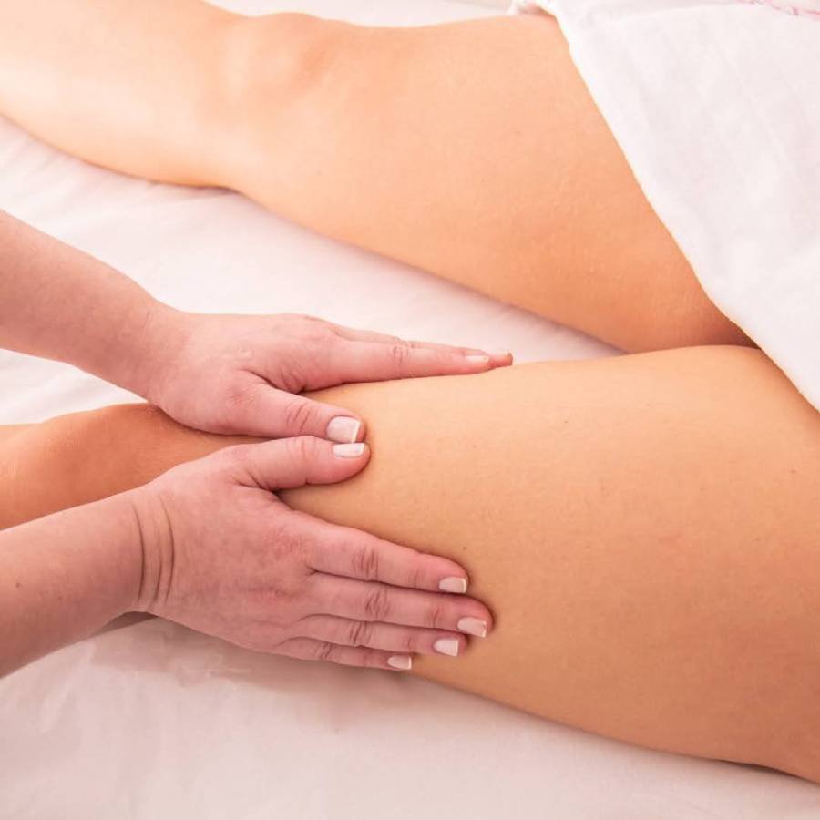 Drenagem Linfática Manual sendo aplicada na coxa de uma paciente por uma massoterapeuta