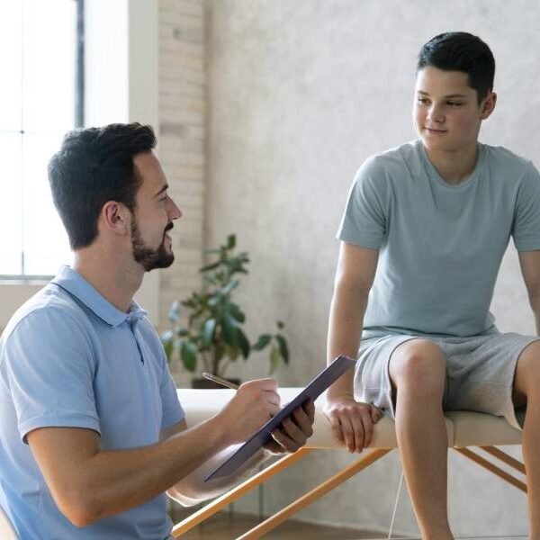 Fisioterapeuta realizando avaliação de paciente que está na maca