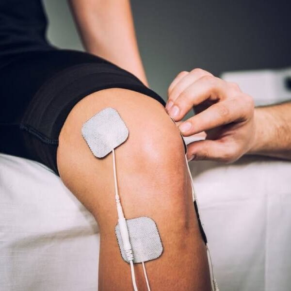 Paciente recebendo eletroterapia no joelho para alívio de dores