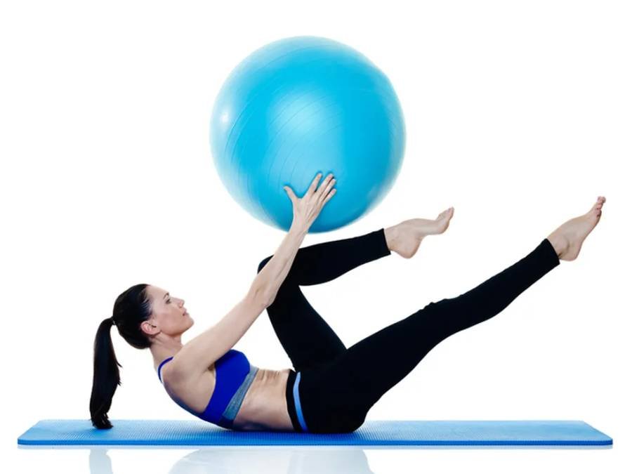 Mulher fazendo postura de pilates com bola