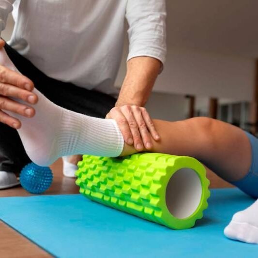 Fisioterapeuta realizando liberação miofascial com rolo de liberação em um paciente